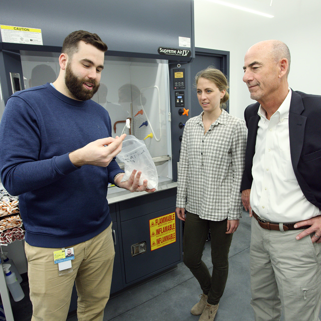 Matthew Davenport, lead researcher for Gemstone Biotherapeutics, shows material to research and development director Laura Dickinson and CEO George Davis. 